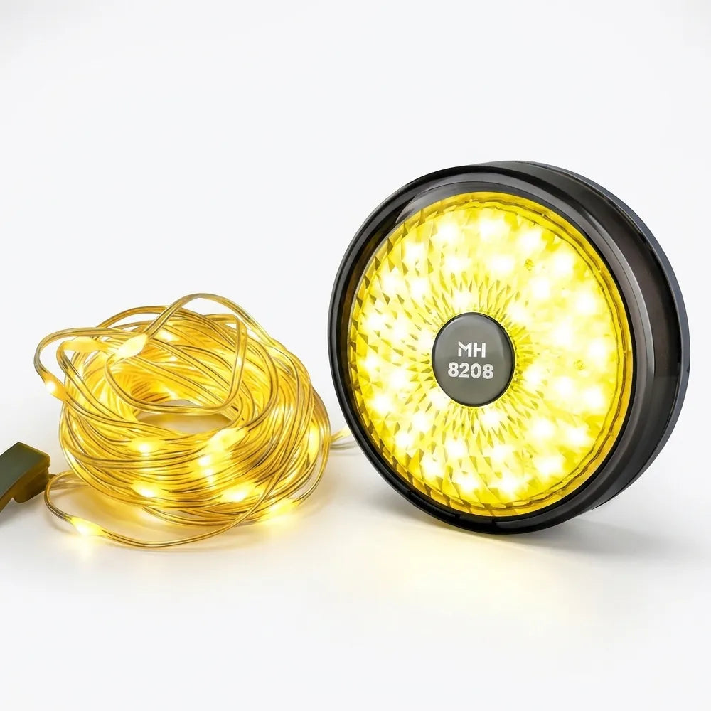 A round black LED light fixture with a bright yellow illuminated face, shown next to a coiled bundle of warm white string lights on a clean white background. The center of the light features a circular badge with the text 'MH 8208'.