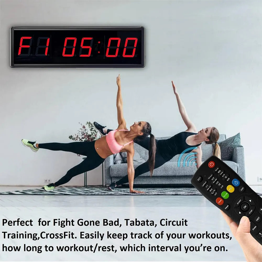Digital clock on a wall with two people exercising in the foreground, remote control in hand.