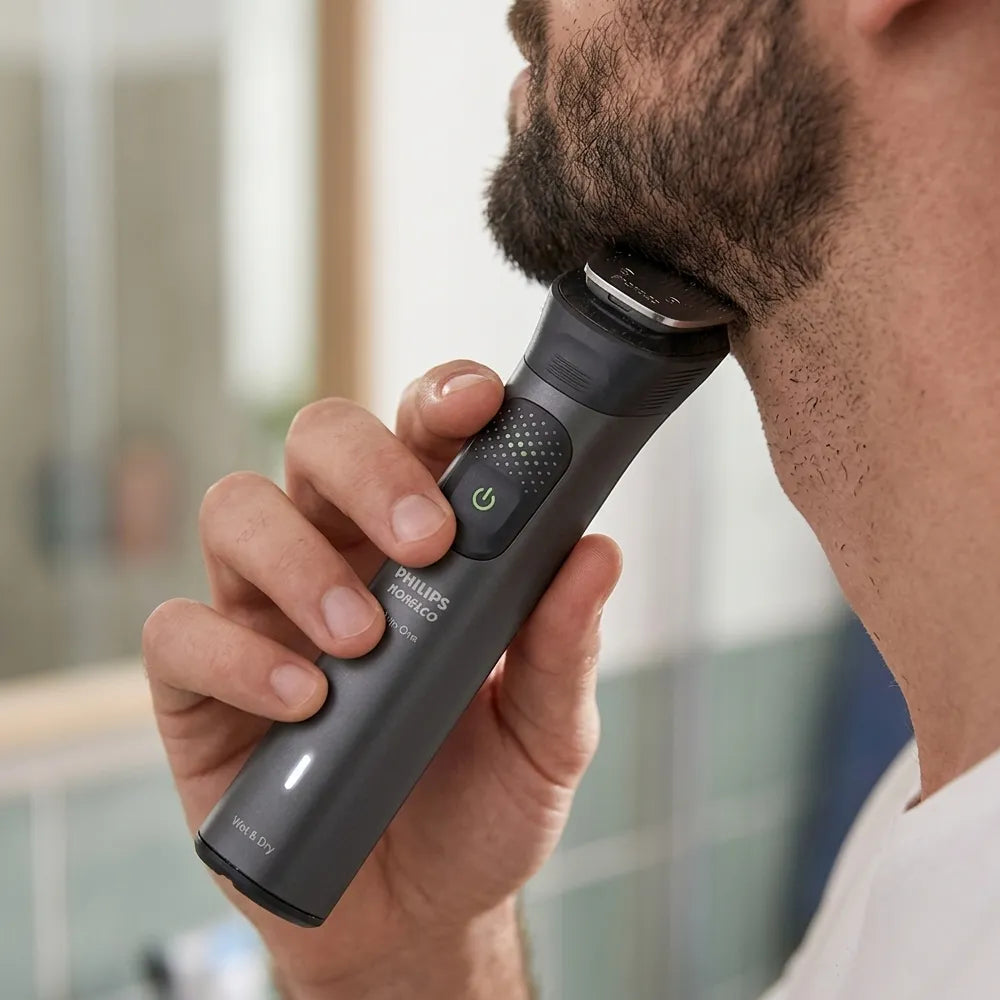 A close-up of a man using a Philips beard trimmer on his beard, showing the device in hand against a softly blurred bathroom background.