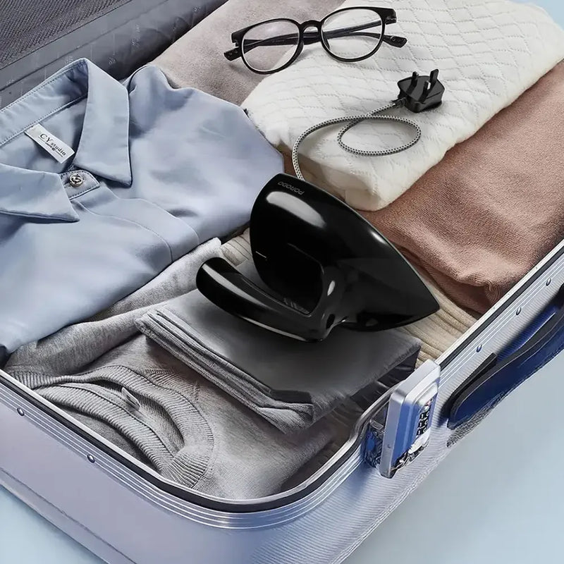 lack Porodo Ironix travel mini iron packed in an open suitcase with folded clothing.