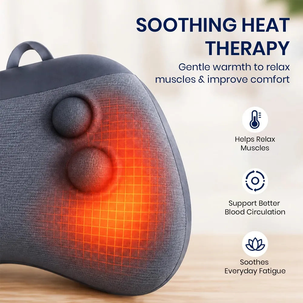 A close-up of a dark gray fabric-covered massage or heat therapy pillow with two round massage nodes and a glowing orange heat grid effect, shown on a light wood surface with marketing text about soothing heat therapy and benefits.