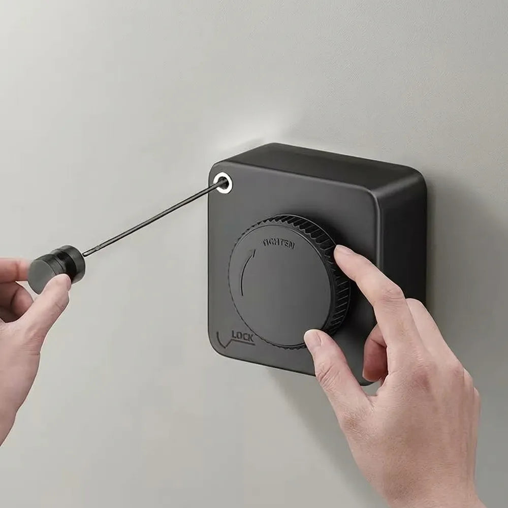 A matte black wall-mounted lock cylinder with a dial labeled 'INCIDENT' and 'LOCK' on the front, shown with two hands interacting with it against a light gray wall.