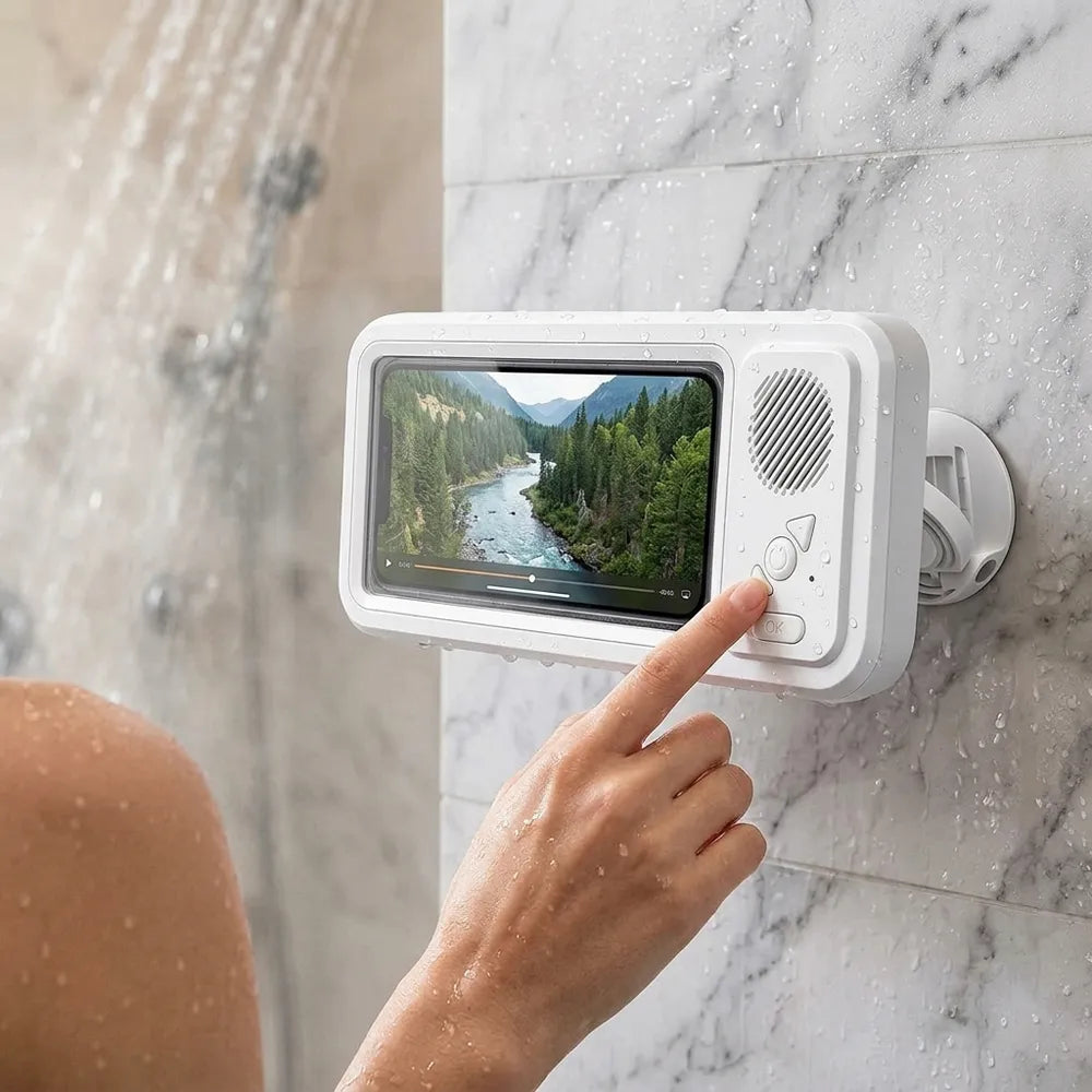 A white waterproof shower monitor with a screen showing a forest river scene, mounted on a marble shower wall with a hand pointing at the display.